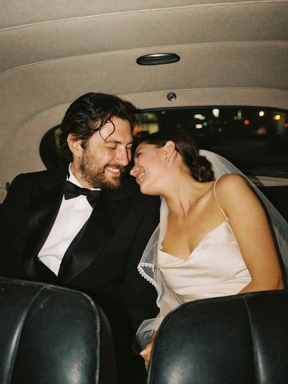 Los dos muy juntos en el asiento de atrás de un auto antiguo