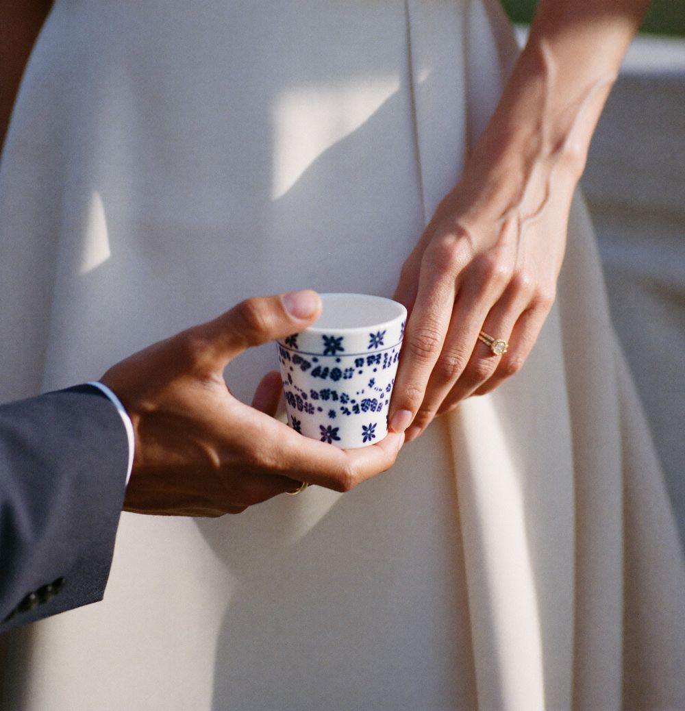 Las manos de los dos sosteniendo una taza de Talavera