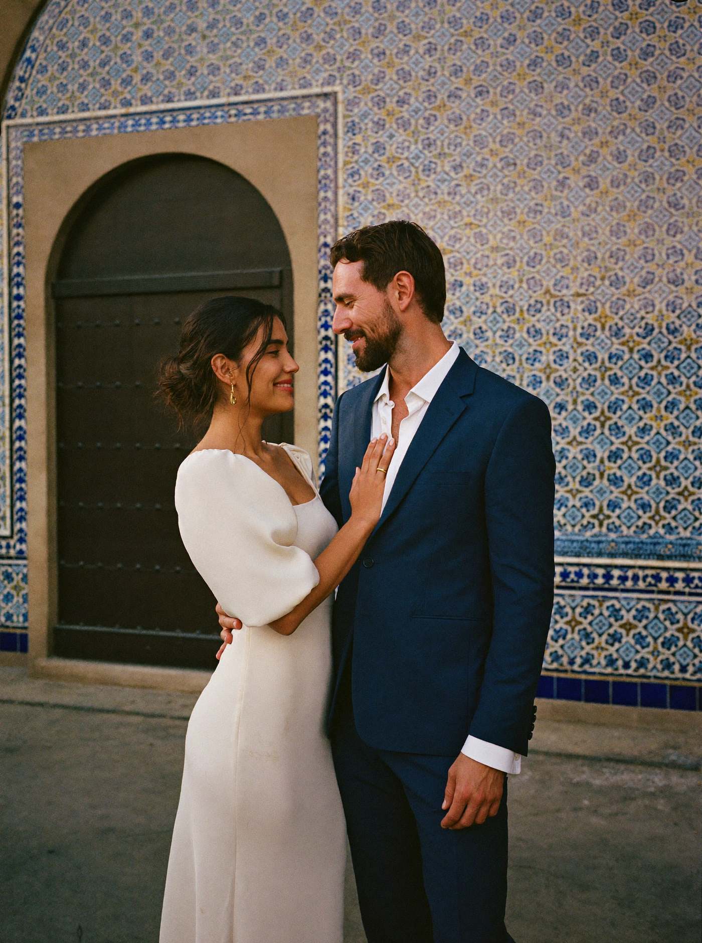 Ximena y Andrés frente a una pared de talavera en Puebla